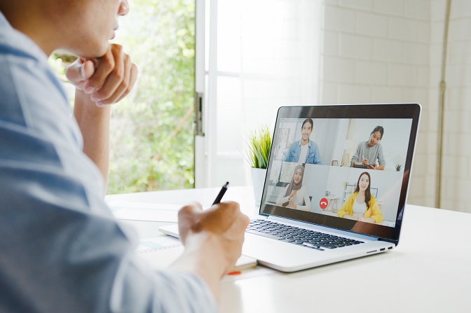 Man die een videoconferentie bijwoont op zijn laptop